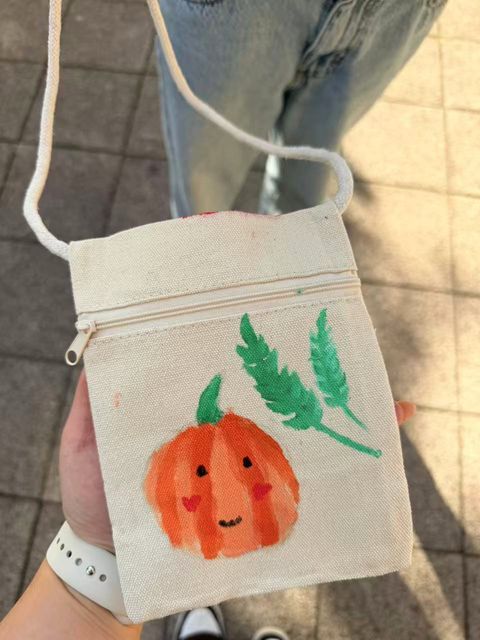 Orange pumpkin painted on a small shoulder bag
