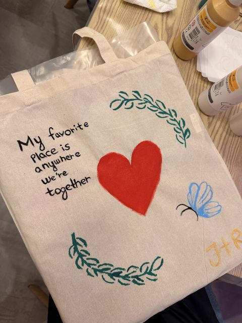 A red heart framed by leaves on a tote bag