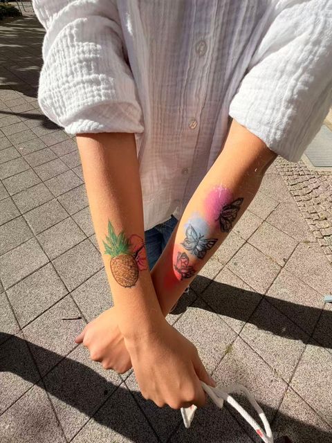 Pineapple and butterfly designs on painted arms
