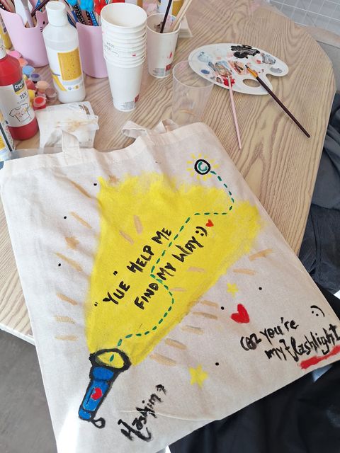 Bright yellow tote bag artwork on the studio table