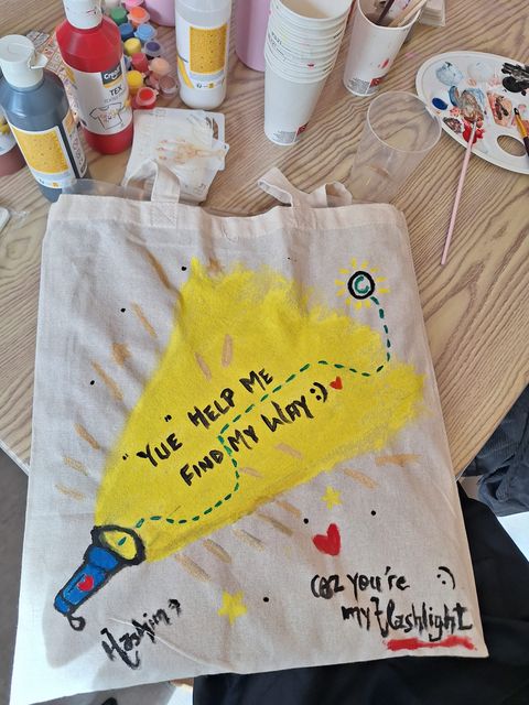 Yellow paint and personal lettering on a tote bag