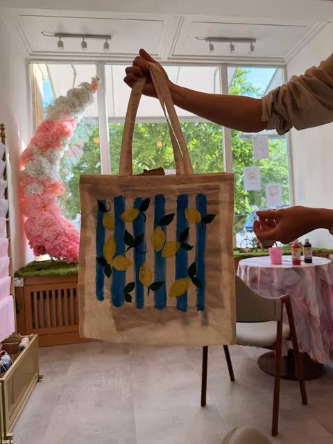 Tote bag with blue and yellow stripes on an easel in the Kleines Glück studio in Magdeburg