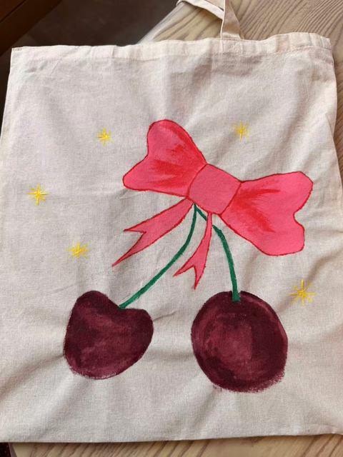 Tote bag painted with a red bow and two cherries