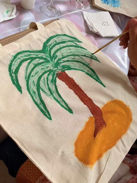 Tote bag painted with a palm tree on a sandy island