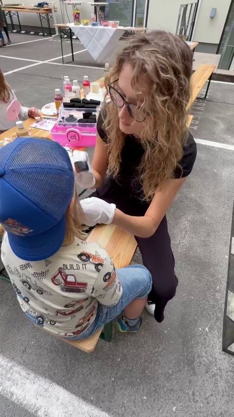 Video: a child having their face painted outdoors