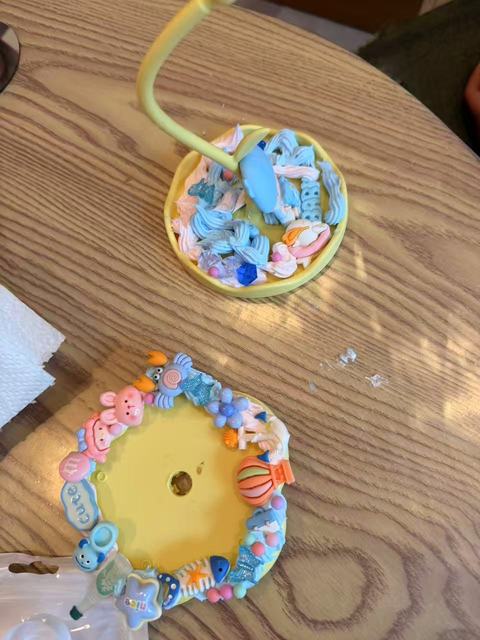 Two round mirrors decorated with blue clay figures and pearls