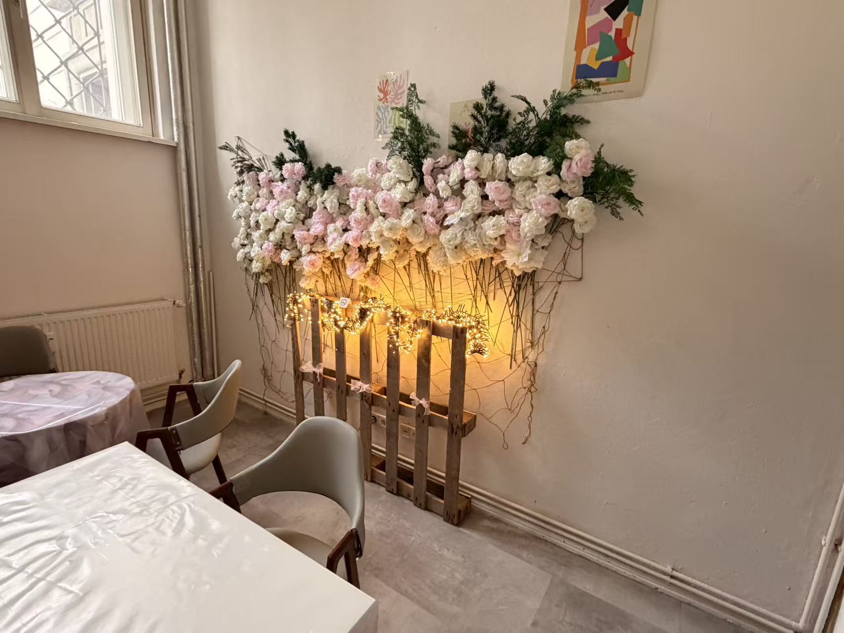 Craft studio in Magdeburg with a flower wall, fairy lights and a set table
