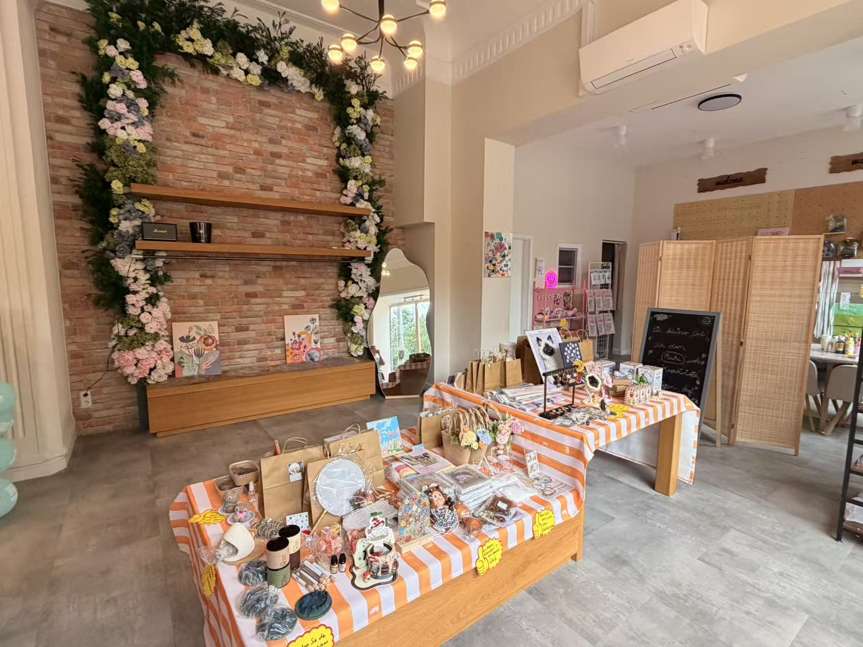 Kleines Glück studio in Magdeburg with a flower-framed brick wall and tables of handmade gifts
